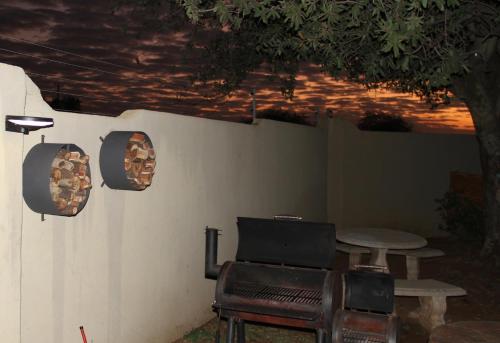 Un patio con una mesa y una mesa y sillas. en Romantic cabin in Big 5 Reserve, en Dinokeng Game Reserve