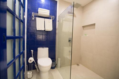 a bathroom with a toilet and a glass shower at GT Hotel Boracay in Boracay