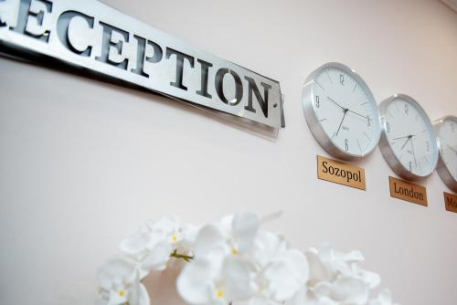 a group of clocks on a wall with the word repetition at Семеен хотел Амон Ра in Sozopol