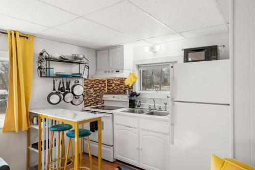 a kitchen with white cabinets and a white refrigerator at Nothing Fancy Older Apt Walk to Downtown King Bed in Dover