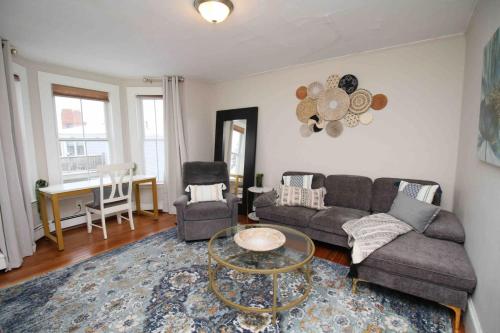 a living room with a couch and a table at Charming Downtown Gem. 2 minutes to Salem. Workspace Included in Beverly