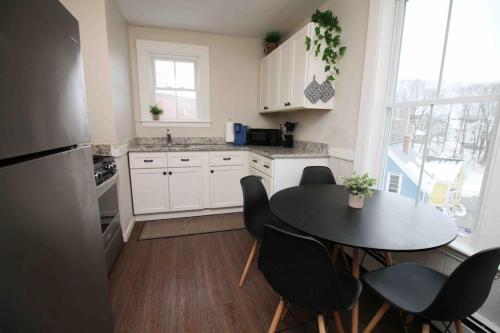 a kitchen with a table and chairs and a window at Charming Downtown Gem. 2 minutes to Salem. Workspace Included in Beverly