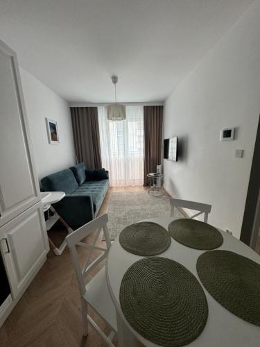 a living room with a table and a couch at Tani Nocleg Ełk - Apartament I love Ełk in Ełk