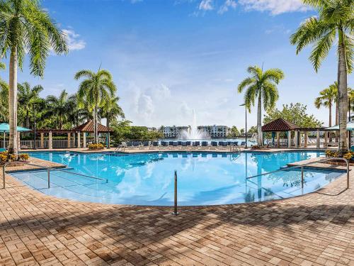 a large swimming pool with palm trees and a fountain at Marriott's Villas at Doral 2BR Apartment with Resort Access in Miami