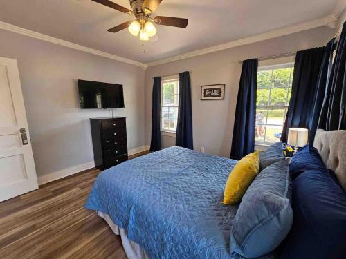 a bedroom with a blue bed and a couch at Serene Refurbished Gem Close to Coast and Downtown in Gulfport