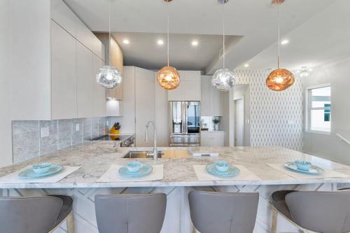 una cocina con una gran isla de cocina con sillas en Chic Ocean Hideaway with Grill, en Cayo Largo