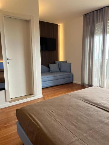a room with a bed and a couch and a mirror at Hotel Italy in Bibione