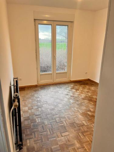 an empty room with a large window and a door at G&J fourmidables in Récourt