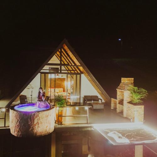 a woman sitting in a tub in a house at night at Glamping Pedro 3 in Estación El Salto