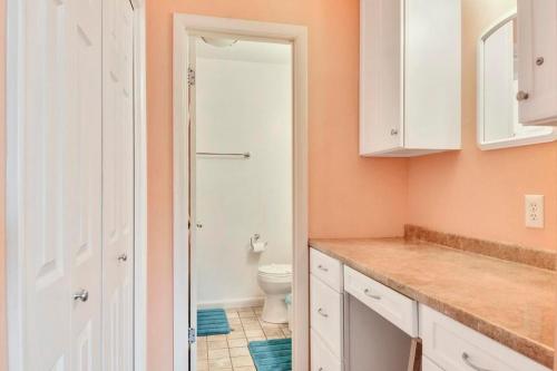 La salle de bains est pourvue de toilettes et d'une armoire blanche. dans l'établissement Scarborough village 308, à Rehoboth Beach