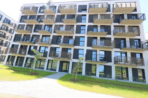 an apartment building with balconies and trees in front of it at Flat for 2 or 1 with Free Parking and Fast Wi-Fi in Vilnius