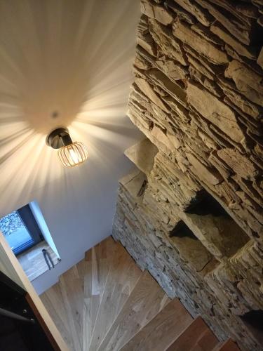 Cette chambre est dotée d'un mur en pierre et d'une lumière. dans l'établissement gite paisible à la ferme, à Sainte-Honorine-de-Ducy