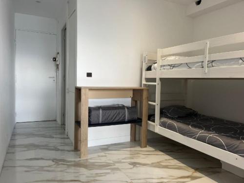 une chambre avec deux lits superposés et une table dans l'établissement La Perle de Juan les Pins, à Juan-les-Pins