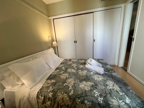 a small bedroom with a bed with a floral bedspread at Apto Ninet Jardins Lorena 1301 in Sao Paulo