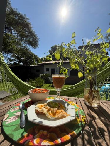 een tafel met een bord eten op een hangmat bij Pousada Bahan Suites privativas - ideal para Casais in Ubatuba