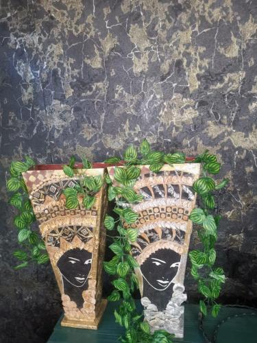 two pieces of art with faces on a wall at House Numba Tatu in Mombasa
