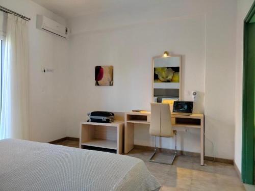 una camera da letto con un letto e una scrivania con un computer portatile di Oliveland Apartments a Kávos