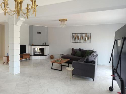 a living room with a couch and a table at Evgeniou House in Nea Triglia in Néa Tríglia