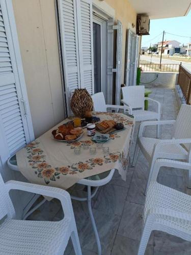 a table with a plate of food on a balcony at Evgeniou House in Nea Triglia in Néa Tríglia