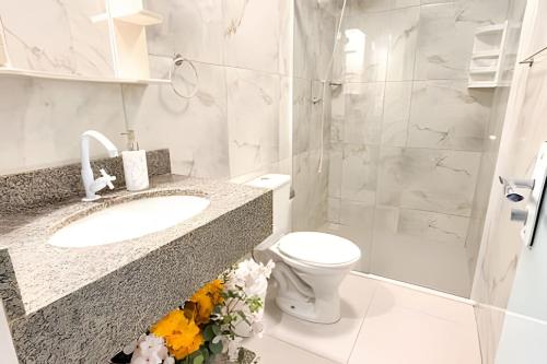 un bagno bianco con lavandino e WC di ASA | Apto Central | 250m do Alles Park | Pomerode a Pomerode