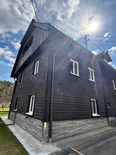 ein schwarzes Haus mit weißen Fenstern an der Seite in der Unterkunft Traditionelles Haus in Trieben