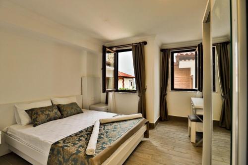 a bedroom with a bed and two windows at Orya Butik Otel in Side