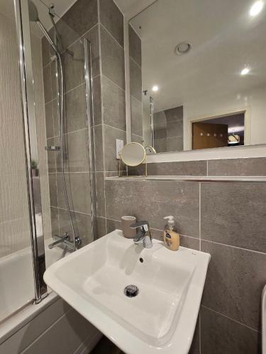 a bathroom with a sink and a shower at Contemporary 2-bedroom apartment with free gated parking, 2 bathrooms - for families, contractors, travellers for business and leisure in Birmingham