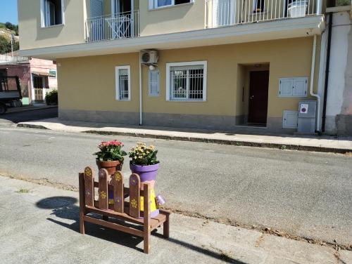 a wooden fence with two potted plants on the street at Agorà 1 in Parghelia