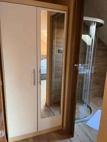 a glass door with a mirror in a room at Malom Club Panzió in Baja