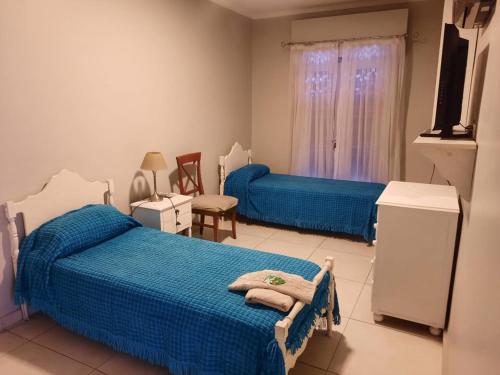 a bedroom with two beds and a television in it at Spectacular House in Barrio Sur with a pool in San Miguel de Tucumán