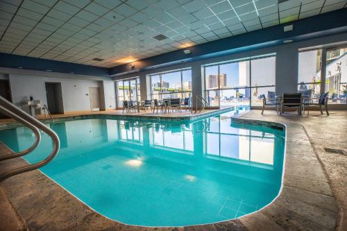 a large swimming pool with blue water in a building at 2100 SqFt Penthouse Suite W/ Strip Views! POOL GYM in Las Vegas