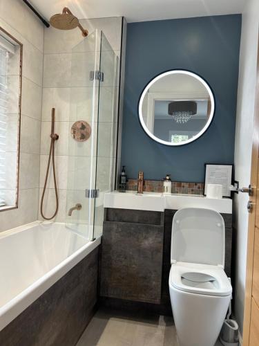 a bathroom with a tub and a toilet and a shower at Wendys house in Sarisbury Green