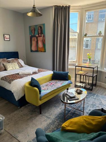 a bedroom with a bed and a couch and a table at Studio 13 Brighton in Brighton & Hove