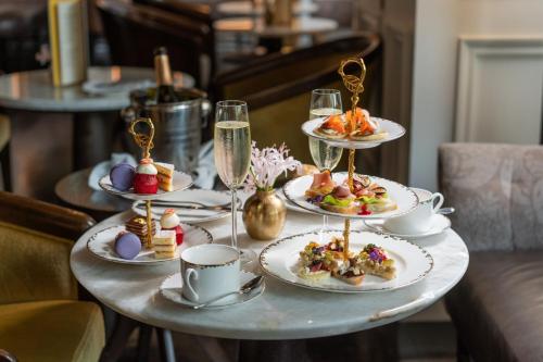 a table with plates of food and glasses of champagne at The Ritz-Carlton New York, Central Park in New York