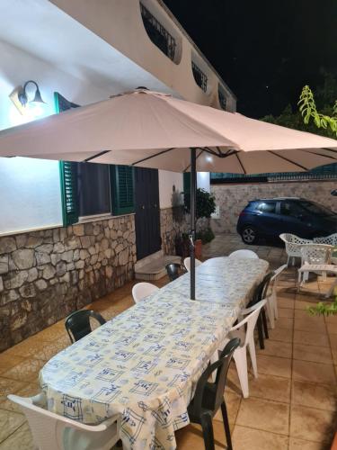 a table with an umbrella on a patio at Ombelico di VenereVilla in Mandra Capreria