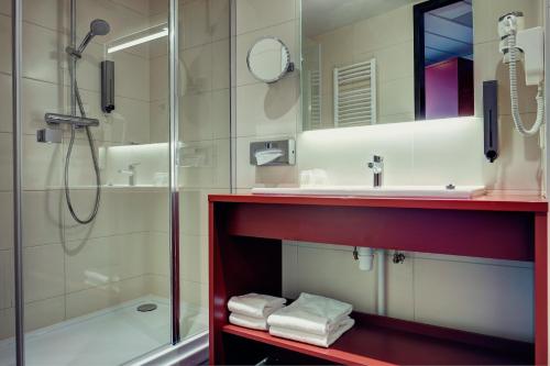 a bathroom with a shower and a sink at AMEDIA Hotel Amsterdam Airport in Schiphol