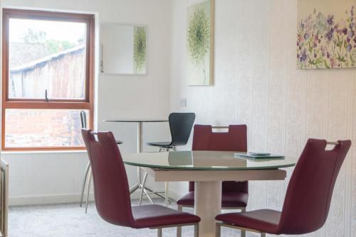 a dining room with a table and red chairs at Rydal Retreat in Carlisle