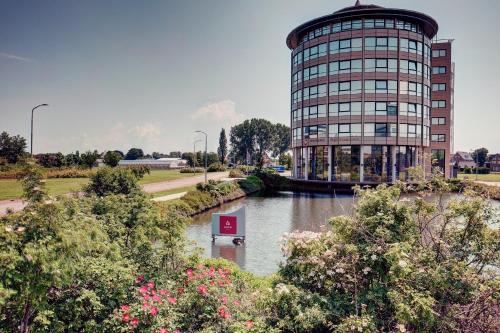 a building with a river in front of a building at Amedia Amsterdam Airport Schiphol, Trademark Collection by Wyndham in Schiphol