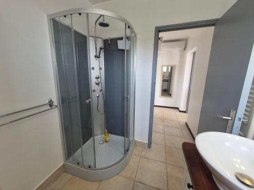 une douche en verre dans une salle de bain avec un lavabo dans l'établissement calista, à Bastia
