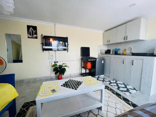 a kitchen with a table in the middle of a room at Tausi Studio Greenspot in Ruiru