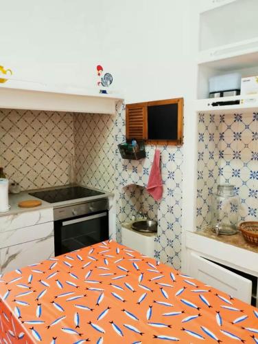 an orange and white kitchen with a table in it at La Maison d'Alinès in Figueira da Foz