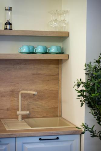 a kitchen counter with a sink and glasses on shelves at White Titanic 204 in Mamaia Sat/Năvodari