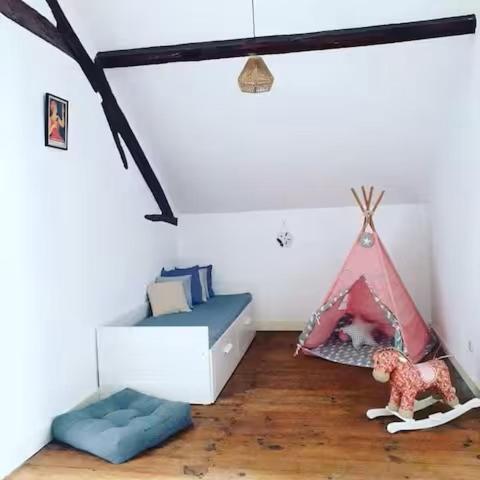 a room with a bed and a dog in a tent at La Maison d'Alinès in Figueira da Foz