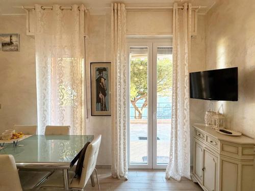 a dining room with a table and a sliding glass door at Giardino, Piscina e Posto Auto - Relax con Vista Mare in Bergeggi