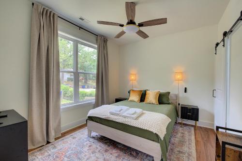 a bedroom with a bed with a ceiling fan and a window at Loft vibes at the city Barn in Spartanburg
