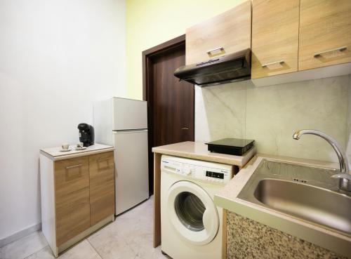 a kitchen with a washing machine and a sink at The Woodnest in Vonitsa
