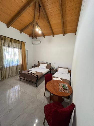 a room with two beds and a table and chairs at The Woodnest in Vonitsa