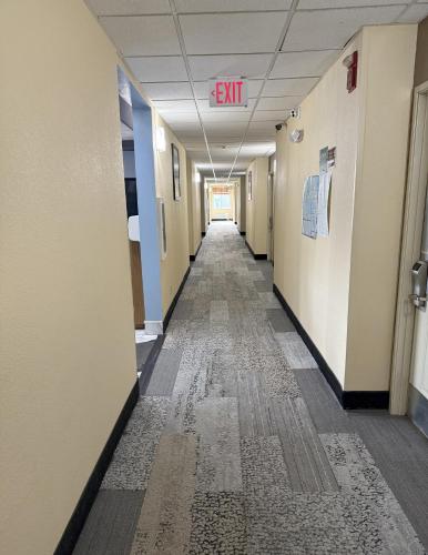 an empty hallway in an office building with a exit sign on the ceiling at Quality Inn Manitowoc in Manitowoc