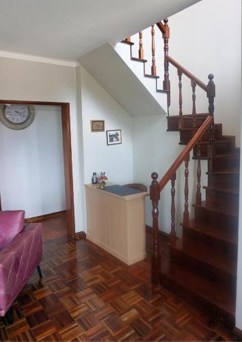 a living room with a staircase with a purple couch at The Cão & Calf in Faja Grande