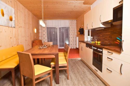 弗拉绍Apartments in Flachau - Salzburger Land 368的带木桌的厨房和餐厅